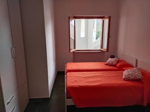カーラゴノネにあるAppartamento Cala Gononeの窓付きの小さな部屋のベッド2台