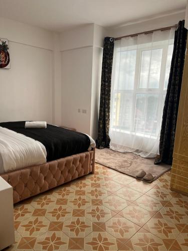 Silva-Mindvalley في ناكورو: غرفة نوم بسرير ونافذة كبيرة