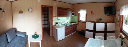 una pequeña cocina y sala de estar en una pequeña casa en Domki WIKA 2 en Ustka