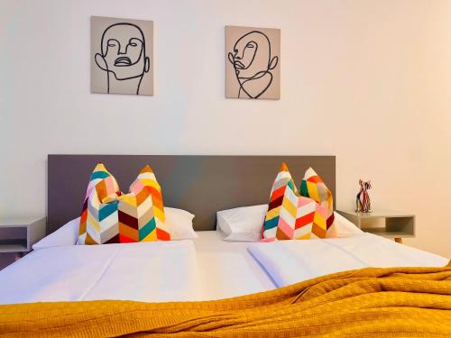 two beds in a bedroom with two pictures on the wall at APSTAY Serviced Apartments - City Center - FREE Parking - Self Check-in in Graz