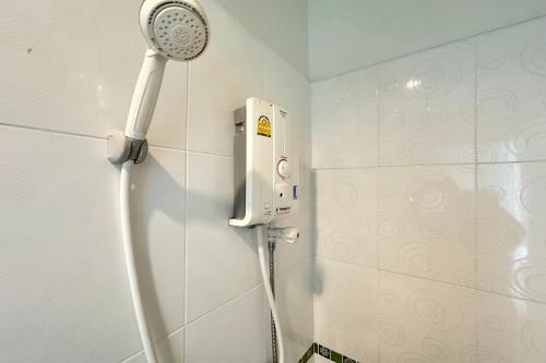 y baño con ducha blanca. en Tara Apartment, en Suratthani