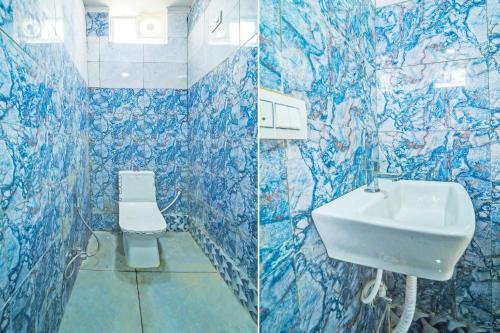 a blue tiled bathroom with a sink and a toilet at OYO Hotel shiv Shakti in Bhopal