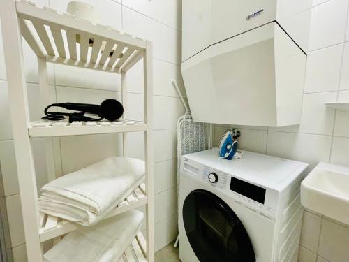 a laundry room with a washing machine and a sink at APSTAY City Center I FREE Parking I Self Check-in in Graz