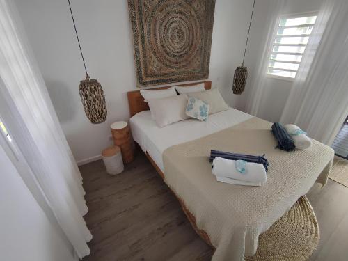 ein Schlafzimmer mit einem Bett mit zwei Handtüchern darauf in der Unterkunft Luxury Waterfront Bungalow + Car in Patio