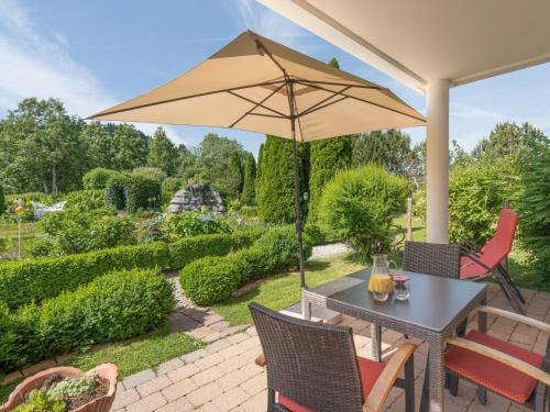 une terrasse avec une table et un parasol dans l'établissement Wellnesshof Blenk, à Wertach