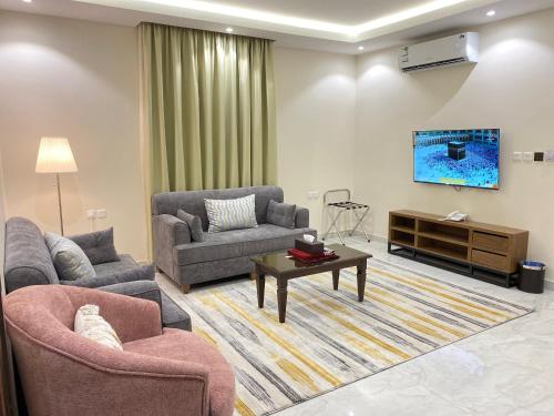sala de estar con 2 sofás y TV en أوفاز للشقق المخدومة en Riad
