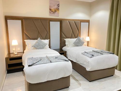 Habitación de hotel con 2 camas con sábanas blancas en أوفاز للشقق المخدومة en Riad