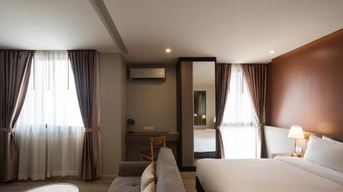 a hotel room with a bed and a couch at The Rise Suites Hotel, Chiang Mai - SHA Extra Plus in Chiang Mai