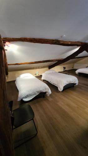 2 bedden in een kamer met witte lakens bij Gite 15 personnes Les Depots in Saint-Didier-sur-Beaujeu