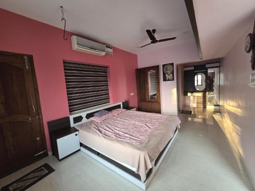 una camera con letto e parete rosa di Geetha Ravi Nilayam a Palakkad