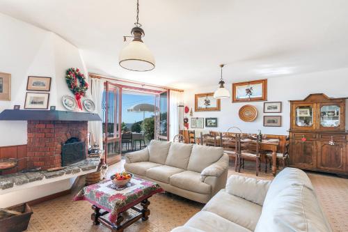 a living room with a couch and a fireplace at Il Poggio Radioso Lake View & Garden - Happy Rentals in Nebbiuno