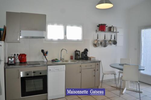 a kitchen with a sink and a stove top oven at Villa des 4 saisons in Saint-Trojan-les-Bains