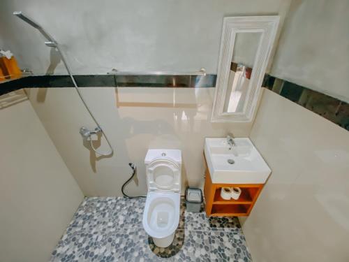 een kleine badkamer met een toilet en een wastafel bij Rural Atmosphere at Bali Coconut House in Delodsema Village in Penginyahan