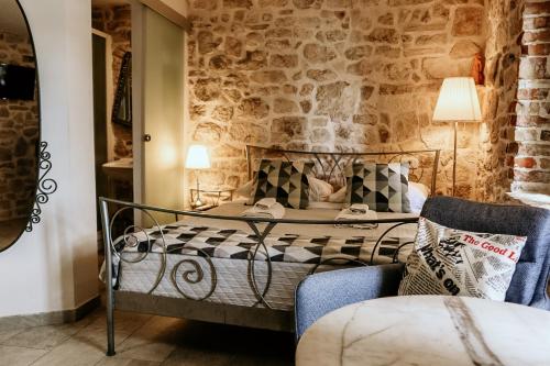 een hotelkamer met een bed en een stoel bij City Rooms Šibenik in Šibenik