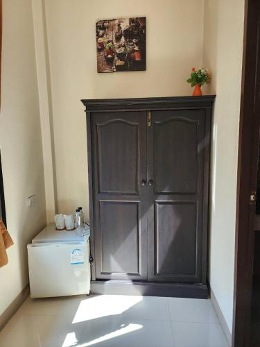 a large black cabinet in a room with a refrigerator at Baan Klong Resort in Damnoen Saduak