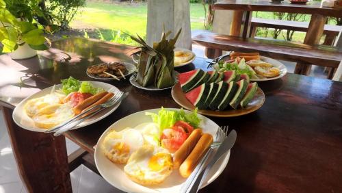 ダムヌーンサドゥワックにあるBaan Klong Resortの食べ物の皿が置かれた木製のテーブル