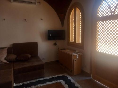 uma sala de estar com um sofá e duas janelas em Guesthouse Nut em Luxor