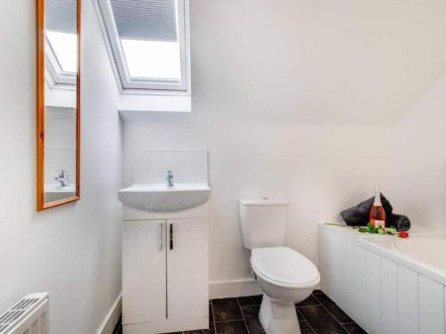 ein Bad mit einem WC, einem Waschbecken und einem Fenster in der Unterkunft Sunset View Apartment in Skinningrove by Bevilla in Skinningrove