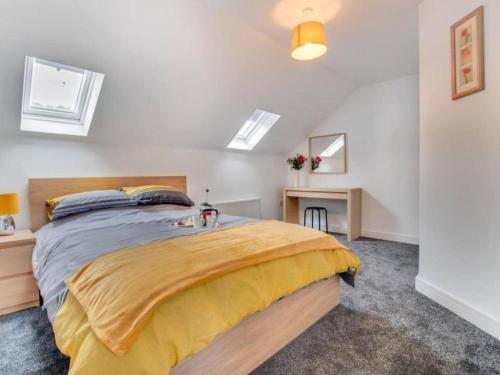 ein Schlafzimmer mit einem großen Bett mit gelber Tagesdecke in der Unterkunft Sunset View Apartment in Skinningrove by Bevilla in Skinningrove