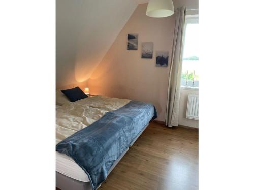 ein Schlafzimmer mit einem Bett und einem großen Fenster in der Unterkunft Alma Comfortable holiday residence in Haselünne
