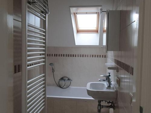 y baño con lavabo y bañera con ventana. en Home Comfortable holiday residence, en Veen