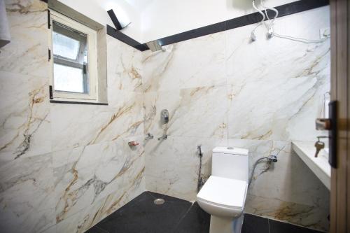 uma casa de banho com um WC, um lavatório e uma banheira em De Vivendi Farm- A Rural Luxury Farmhouse Getaway em Bahora