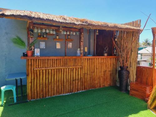 a bar with a wooden fence and green grass at CiNta Hotel in Boracay