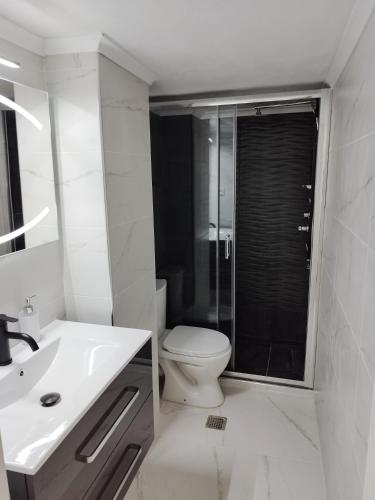 a white bathroom with a toilet and a sink at Cozy apartment Peraia in Perea