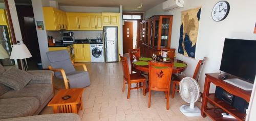 a kitchen and a living room with a table and chairs at Seaview Condo B63 in Mae Pim