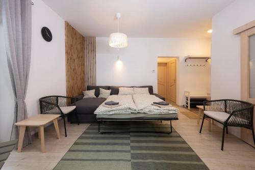 a living room with a couch and a table and chairs at Apartment Medved Pokljuka in Zgornje Gorje