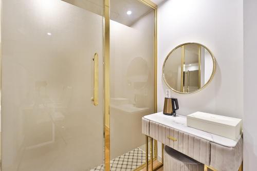 a bathroom with a shower and a sink and a mirror at Den Basta Hotel Hadan in Busan