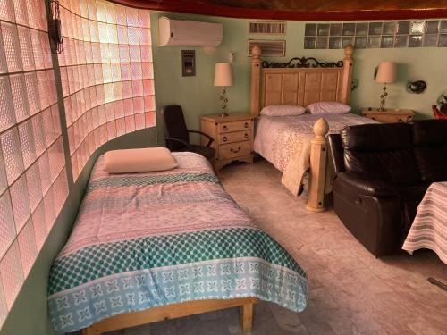 sypialnia z 2 łóżkami i kanapą w obiekcie Habitación Privada Los Cabos w mieście Cabo San Lucas