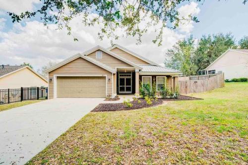 a house with a garage and a fence at Spacious Home - Heated LED Pool & Ping Pong in Minneola