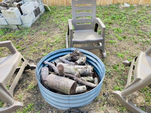 a pile of logs in a barrel next to chairs at Spacious Home - Heated LED Pool & Ping Pong in Minneola