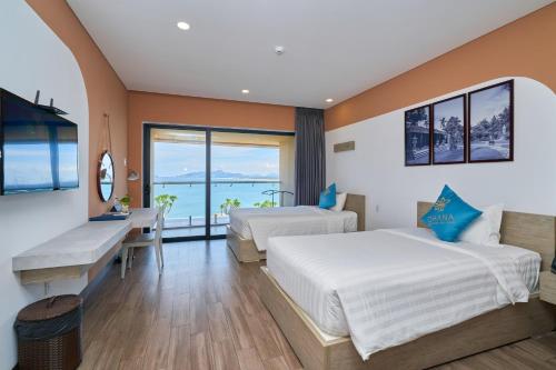 two beds in a room with a view of the ocean at Ohana Village in Phương Phi