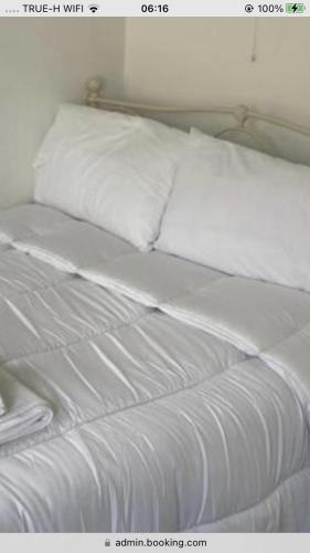 a white bed with white sheets and pillows at Surf kinsale in Kinsale