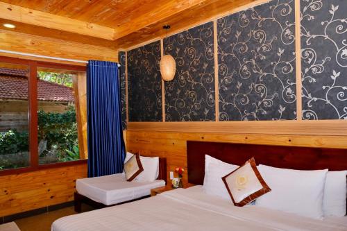 a bedroom with two beds and a window at Tan Son Nhat Con Dao Resort in Con Dao