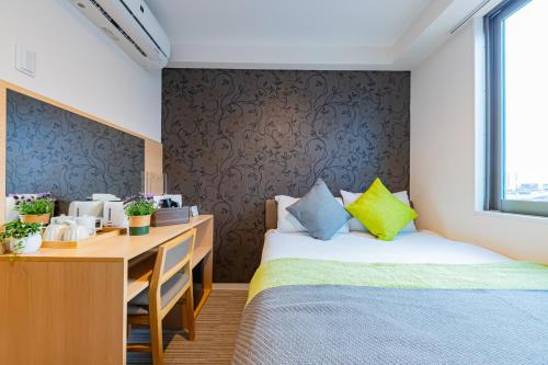 a room with two beds and a desk with a desk at JA Hotel Namba-SOUTH難波南 in Osaka