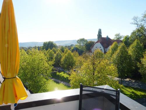 a balcony with a umbrella and a view of a house at Parkhotel Pyrmont in Bad Pyrmont