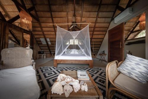 a room with a bed and a table and a couch at The Beach House Ocam Ocam in Busuanga