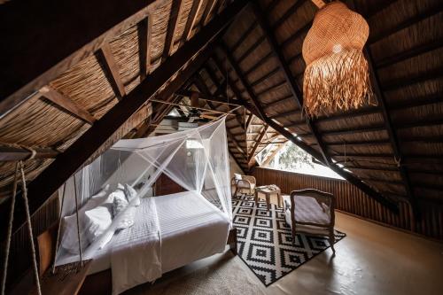 a bedroom with a bed and a chandelier at The Beach House Ocam Ocam in Busuanga