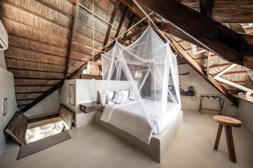 a bedroom with a bed with mosquito net at The Beach House Ocam Ocam in Busuanga