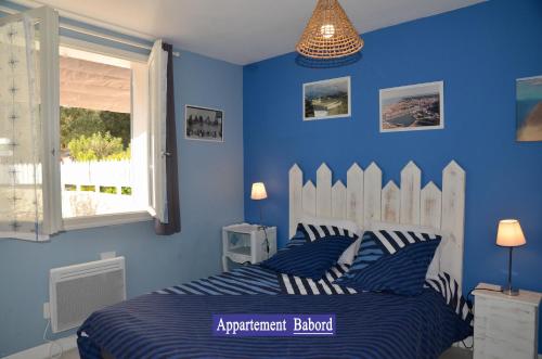 a blue bedroom with a bed and a window at Villa des 4 saisons in Saint-Trojan-les-Bains