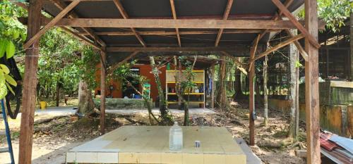 a wooden pavilion with a table in a park at Campsite House In a Farm in Cukai