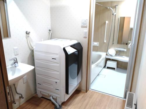 ein Badezimmer mit einem TV auf einer Kommode neben einem Waschbecken in der Unterkunft Yubitoya - Vacation STAY 44210v in Kawaba