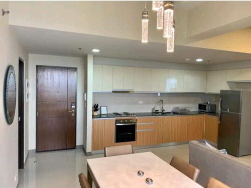 a kitchen with a table and a kitchen with a refrigerator at 8 Newtown Boulevard by Hiverooms in Lapu Lapu City