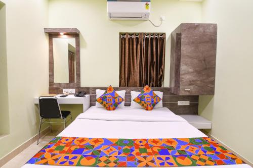 a bedroom with a bed with a colorful blanket on it at FabHotel The Sunshine Residency in Kolkata