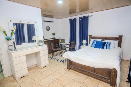 a bedroom with a bed and a desk and a mirror at Casa Nella in Tamarindo