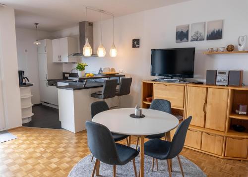uma sala de estar com mesa e cadeiras e uma cozinha em Ferienwohnung Uhl em Velden am Wörthersee