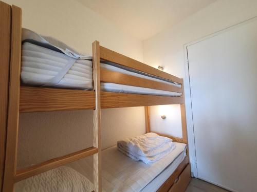 a room with two bunk beds and a mirror at Résidence Les Carlines - Studio pour 4 Personnes 664 in Les Orres